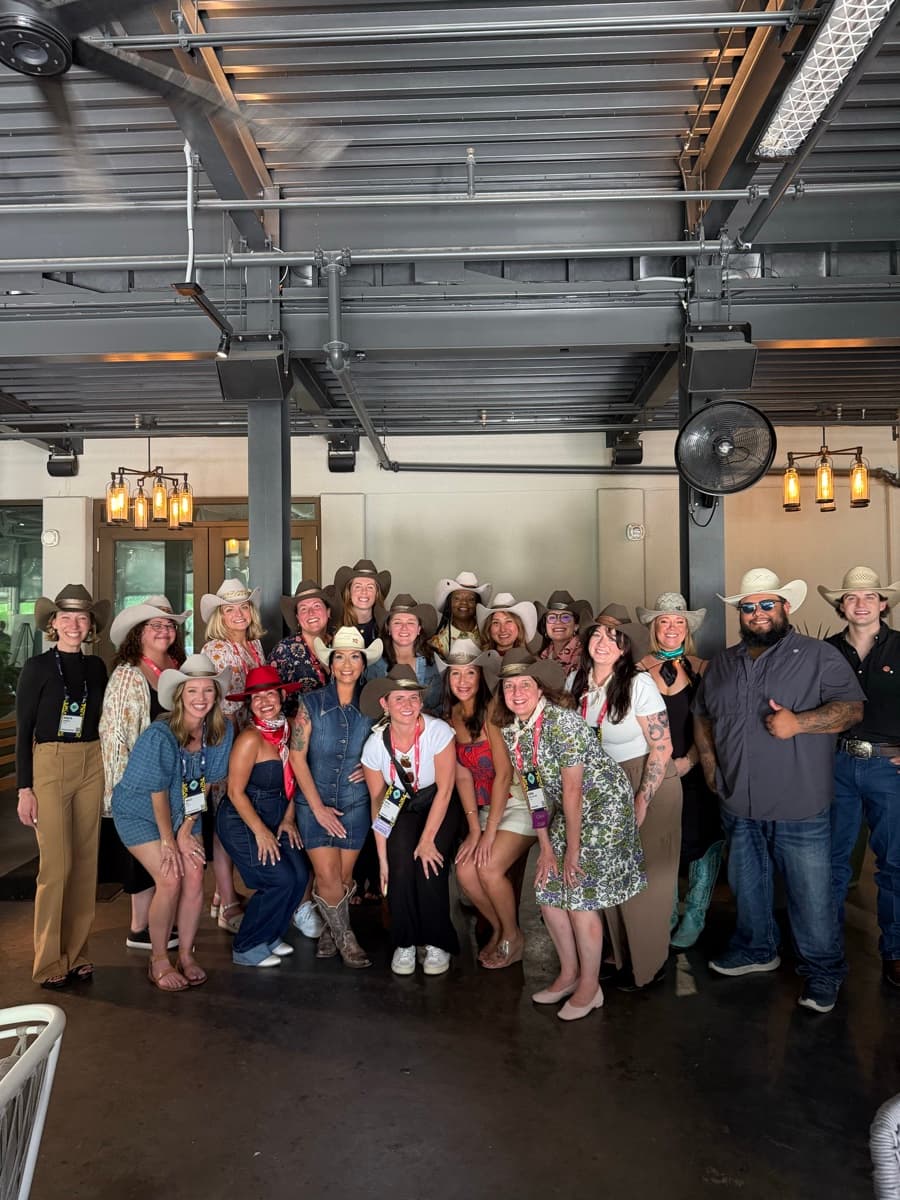Large group of corporate event attendees with custom hats