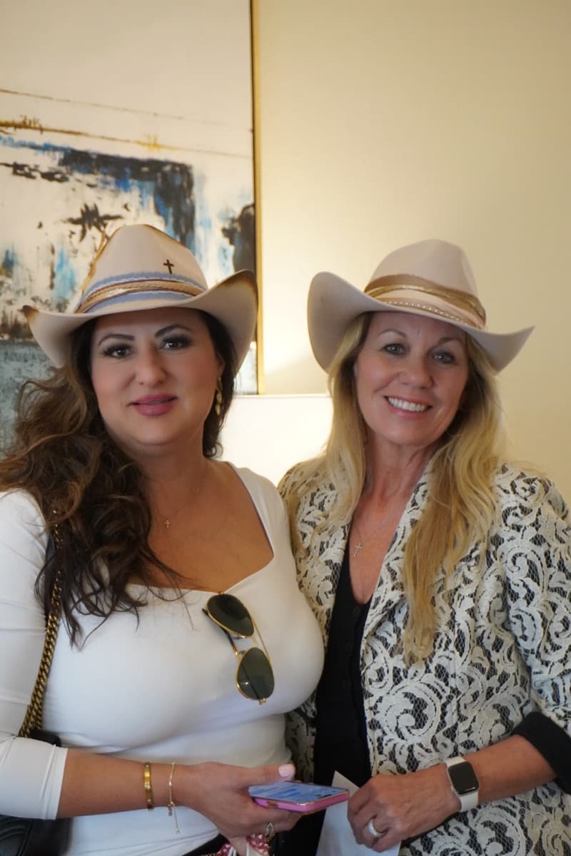 Two guests wearing their finished cream cowboy hats