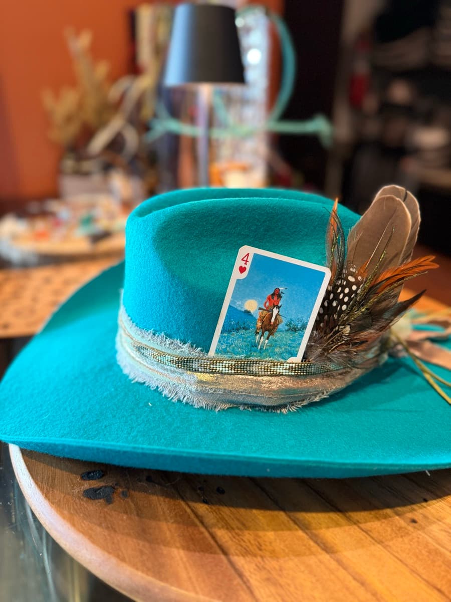 Close-up of a custom teal felt hat