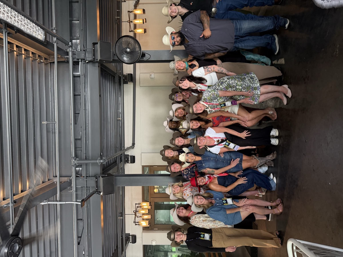 Large group of corporate event attendees with custom hats