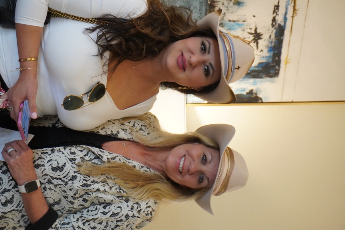 Two guests wearing their finished cream cowboy hats