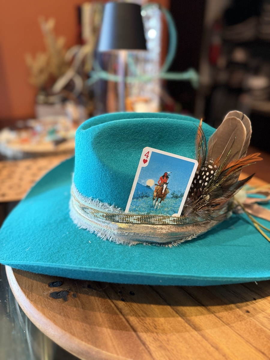 Close-up of a custom teal felt hat